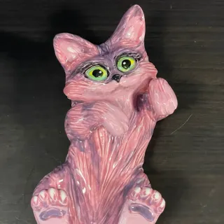 A ceramic cat lying on its back.