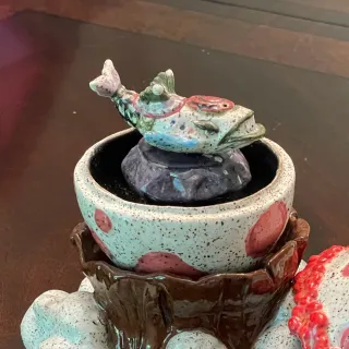 A ceramic egg on top of a mountain with a windfish inside it